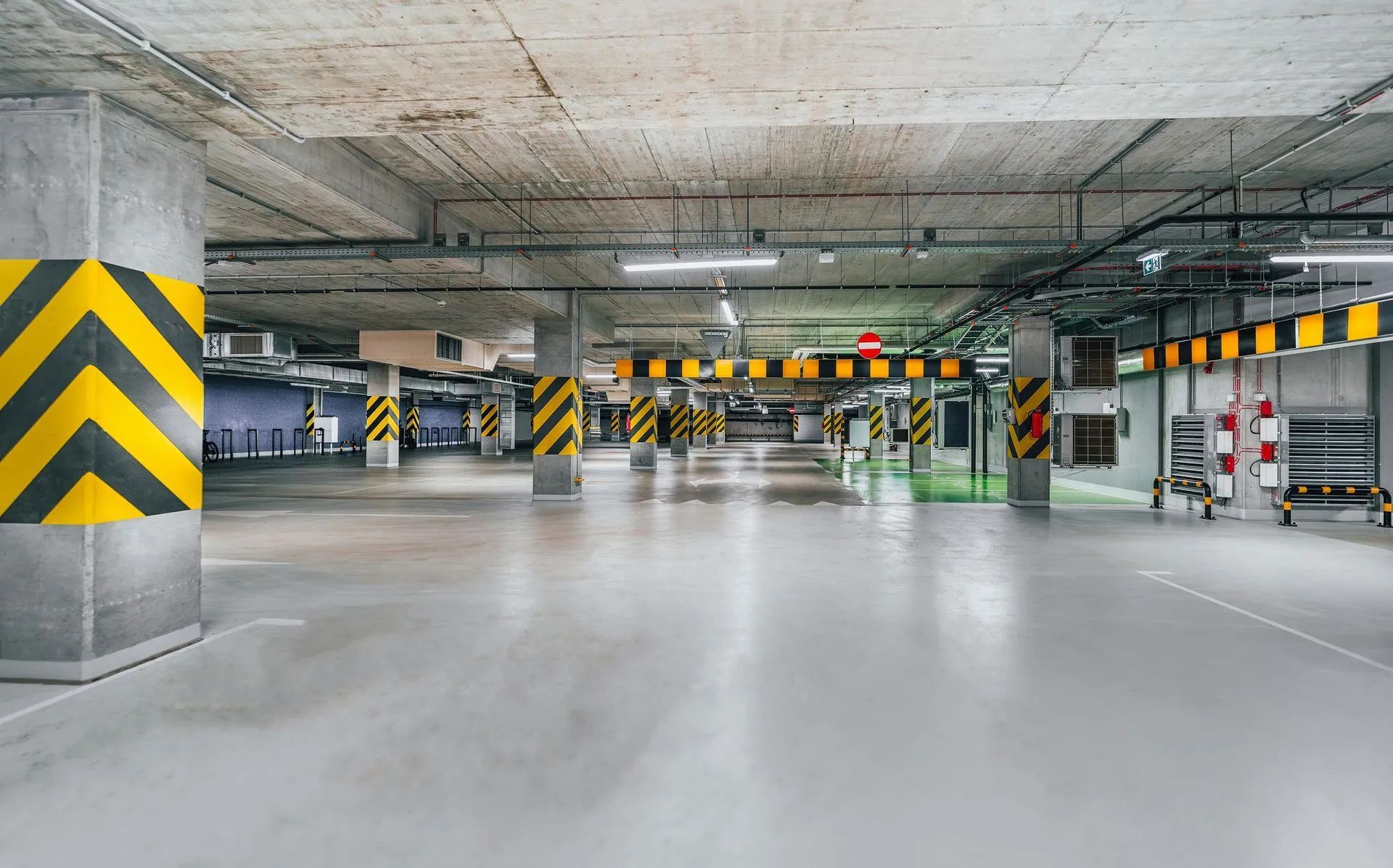 Spacious commercial concrete parking structure with yellow-striped safety columns