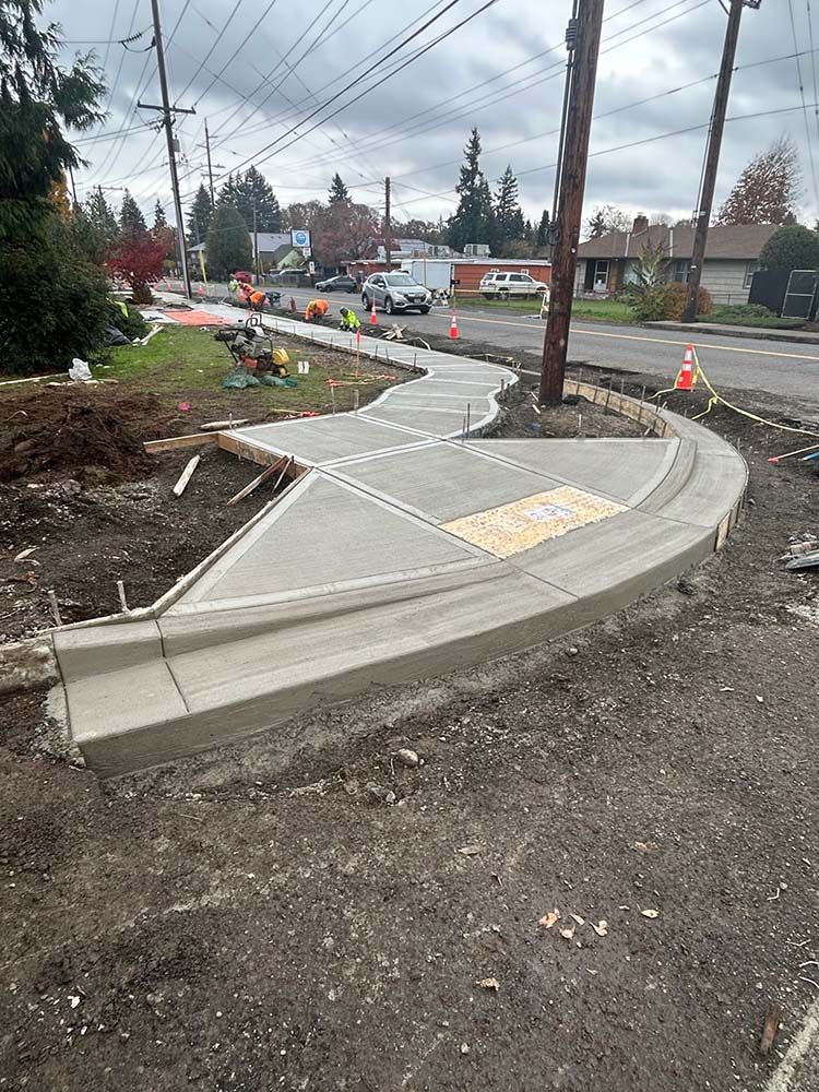 Newly formed concrete curb work curving along a residential street under construction