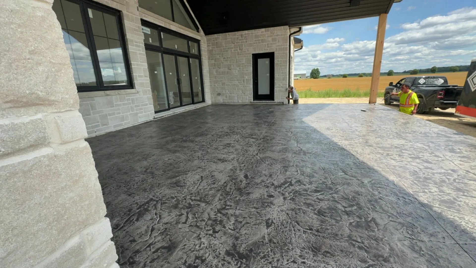 Freshly finished stamped concrete patio with a stone texture outside a modern building