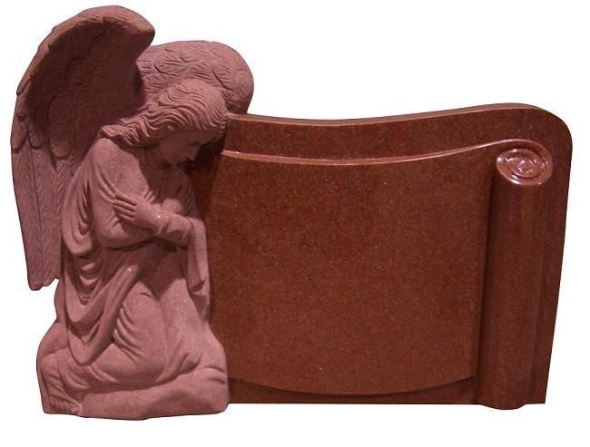 A red-brown angel statue leaning beside a curved plaque or gravestone