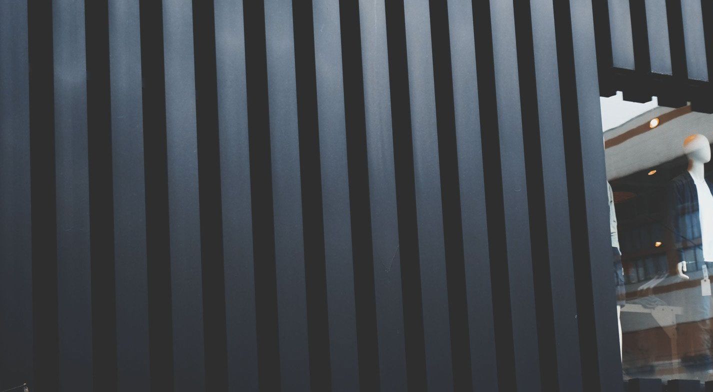 a black striped wall with a reflection of a building