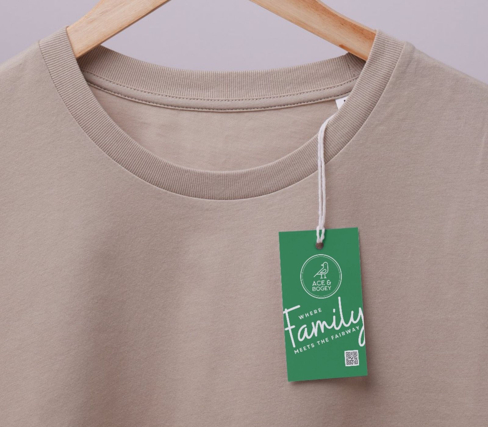 Beige T-shirt on a wooden hanger with a green retail tag.
