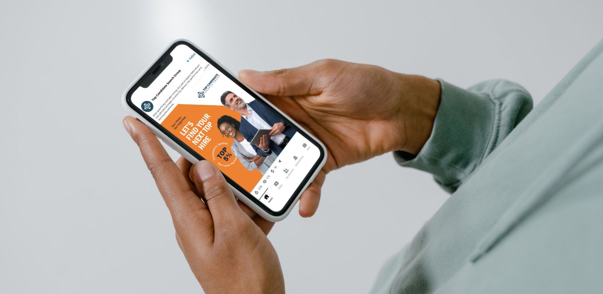 Hands holding a smartphone displaying an social media post with a person illustration.