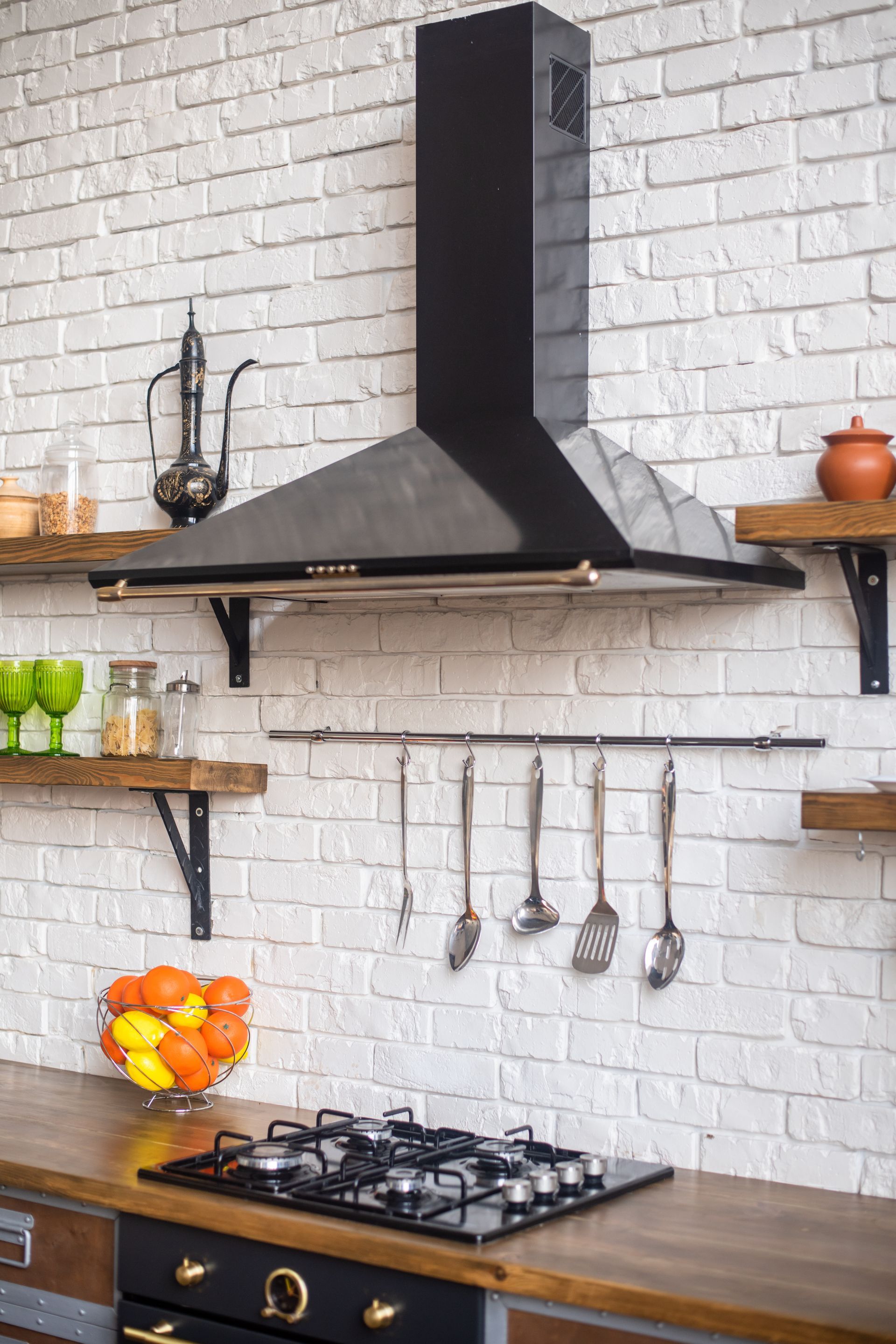An inviting kitchen featuring a sleek stovetop oven and a stylish hood.