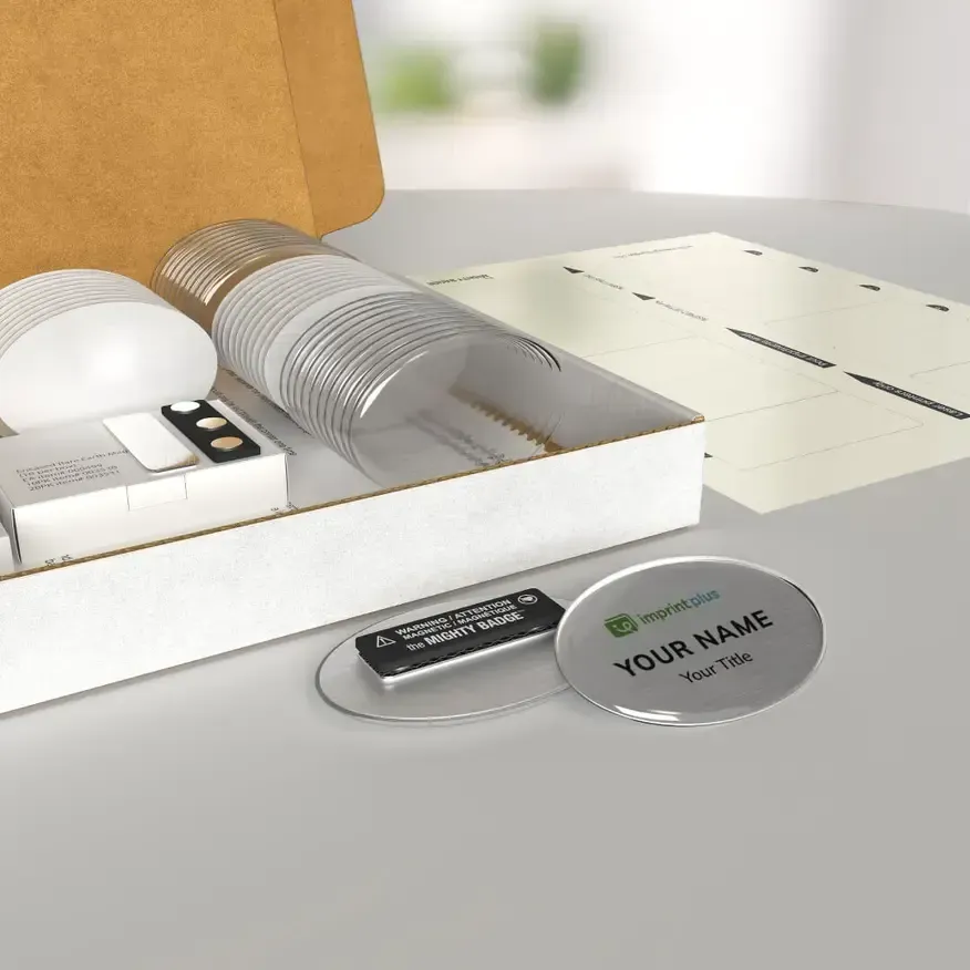 Caja abierta con kit de aseo blanco, tarjeta doblada y llavero plateado personalizado sobre una mesa de luz.