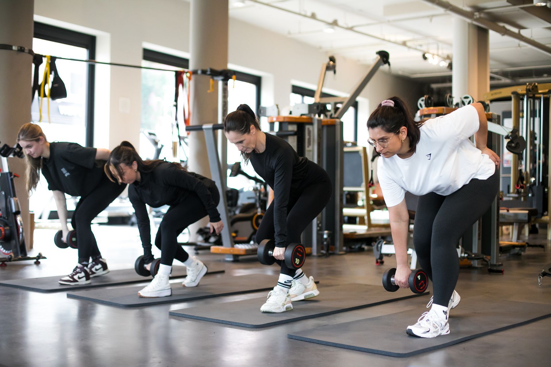 Een groep mensen tilt halters op in een sportschool.