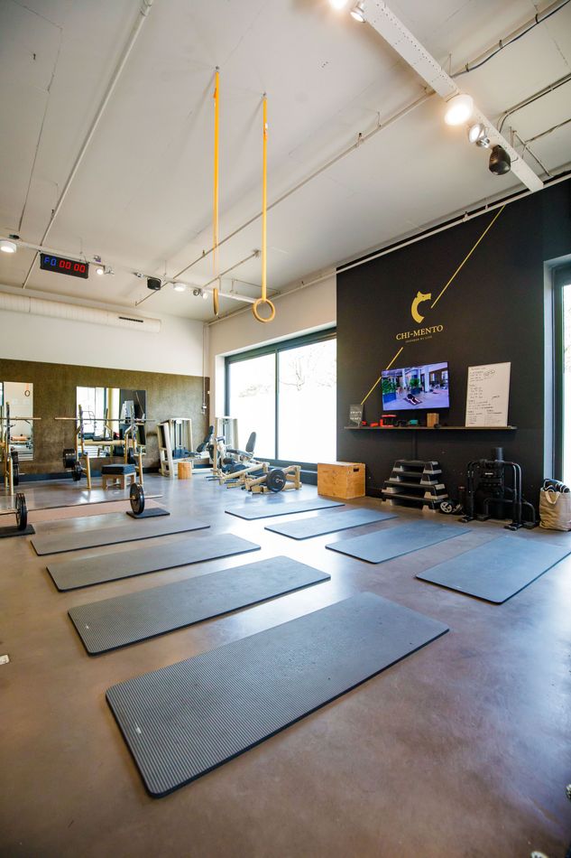 Een sportschool met veel matten op de vloer en een televisie aan de muur.