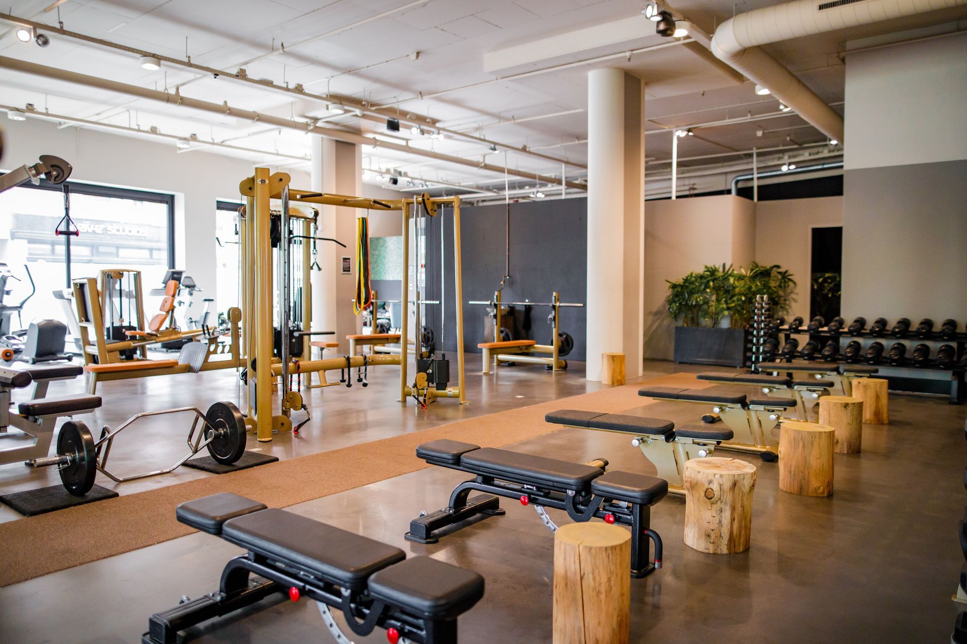 Een grote fitnessruimte met veel banken en krukken.