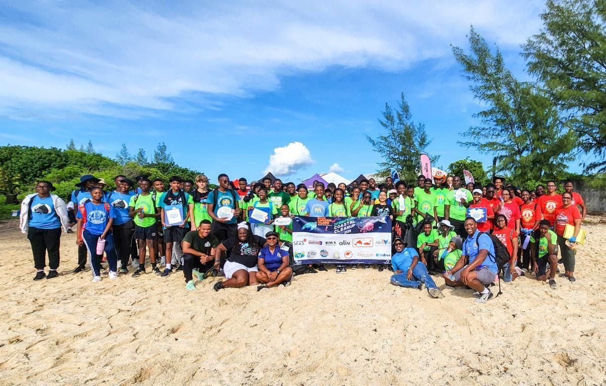 Group of people on a beach holding signs