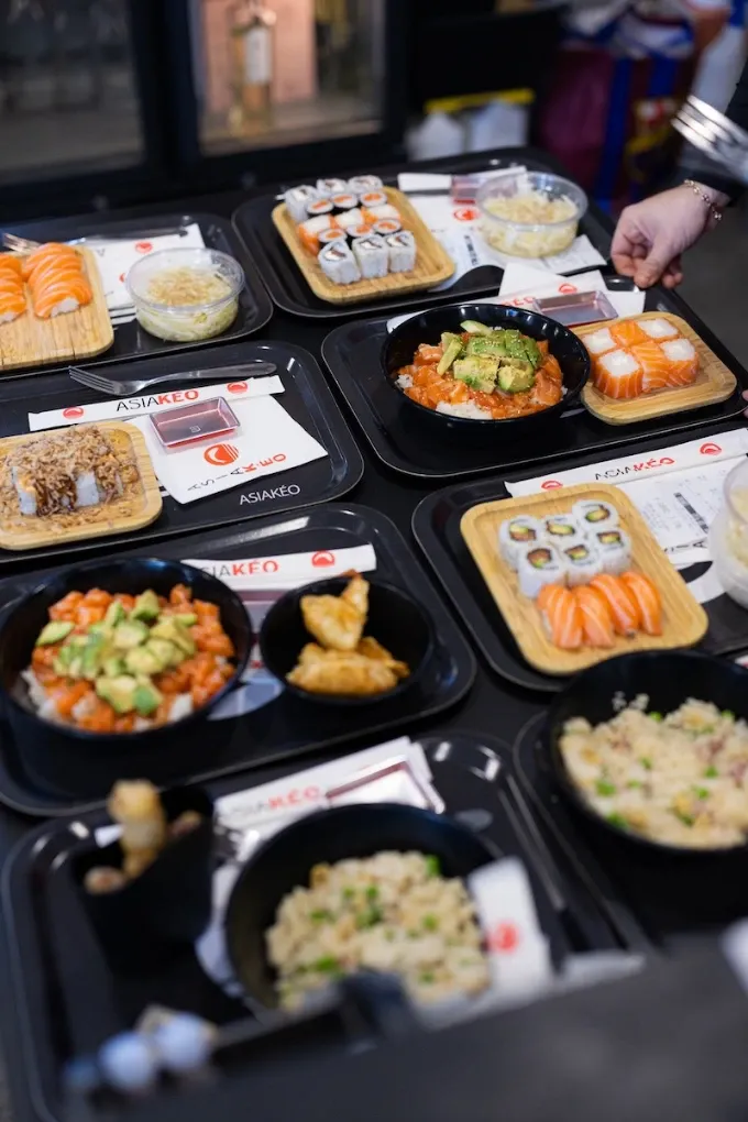 Nouilles sautées aux crevettes servies dans un bol noir, garnies de germes de soja et de graines de sésame.