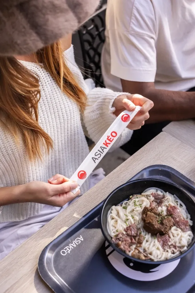 Repas de sushis sur un plateau avec bouteille d'eau, gobelet, sauce soja et salade.