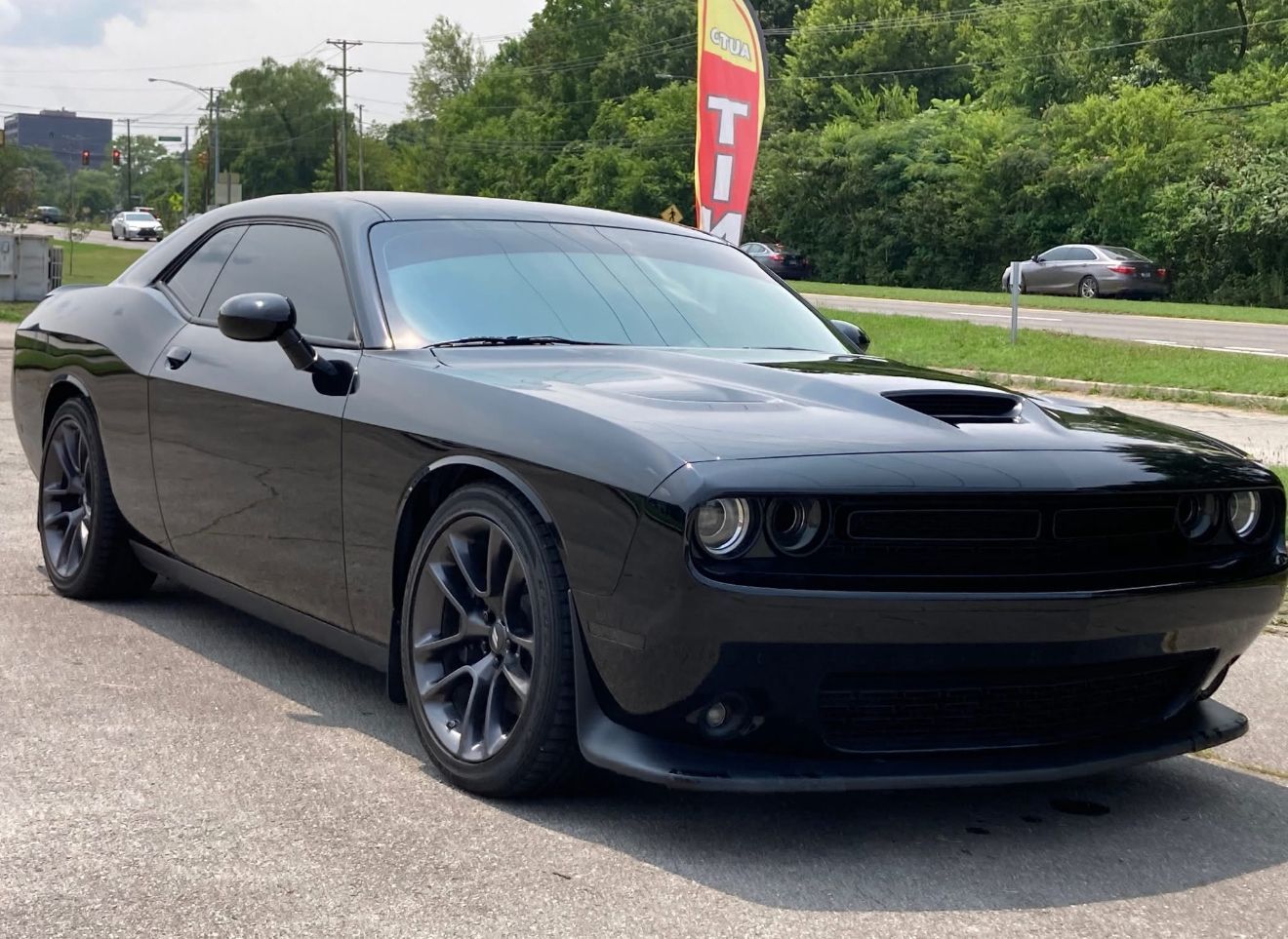 Black Dodge Challenger parked on a city street.