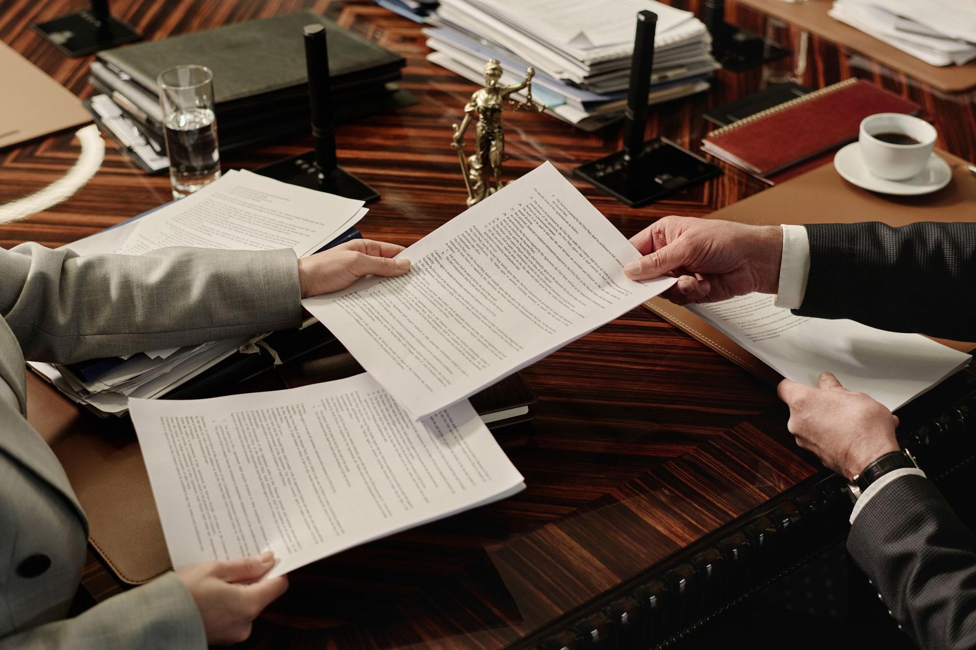 Two business professionals in suits reviewing documents, discussing strategy.