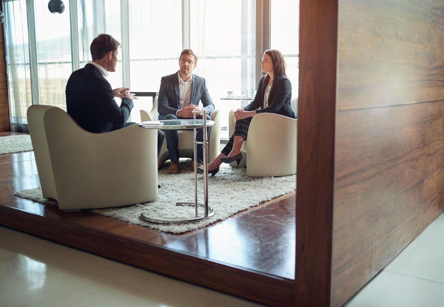 Two business professionals in suits reviewing documents, discussing strategy.