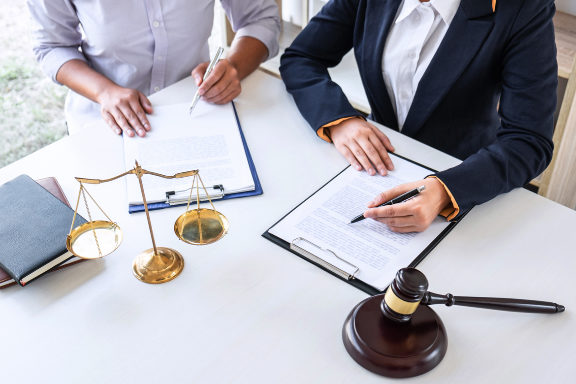 Two business professionals in suits reviewing documents, discussing strategy.