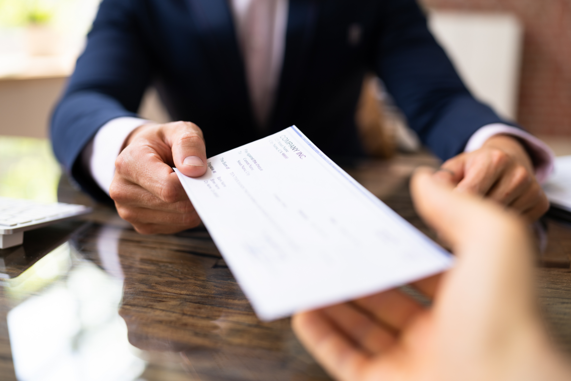 Two business professionals in suits reviewing documents, discussing strategy.