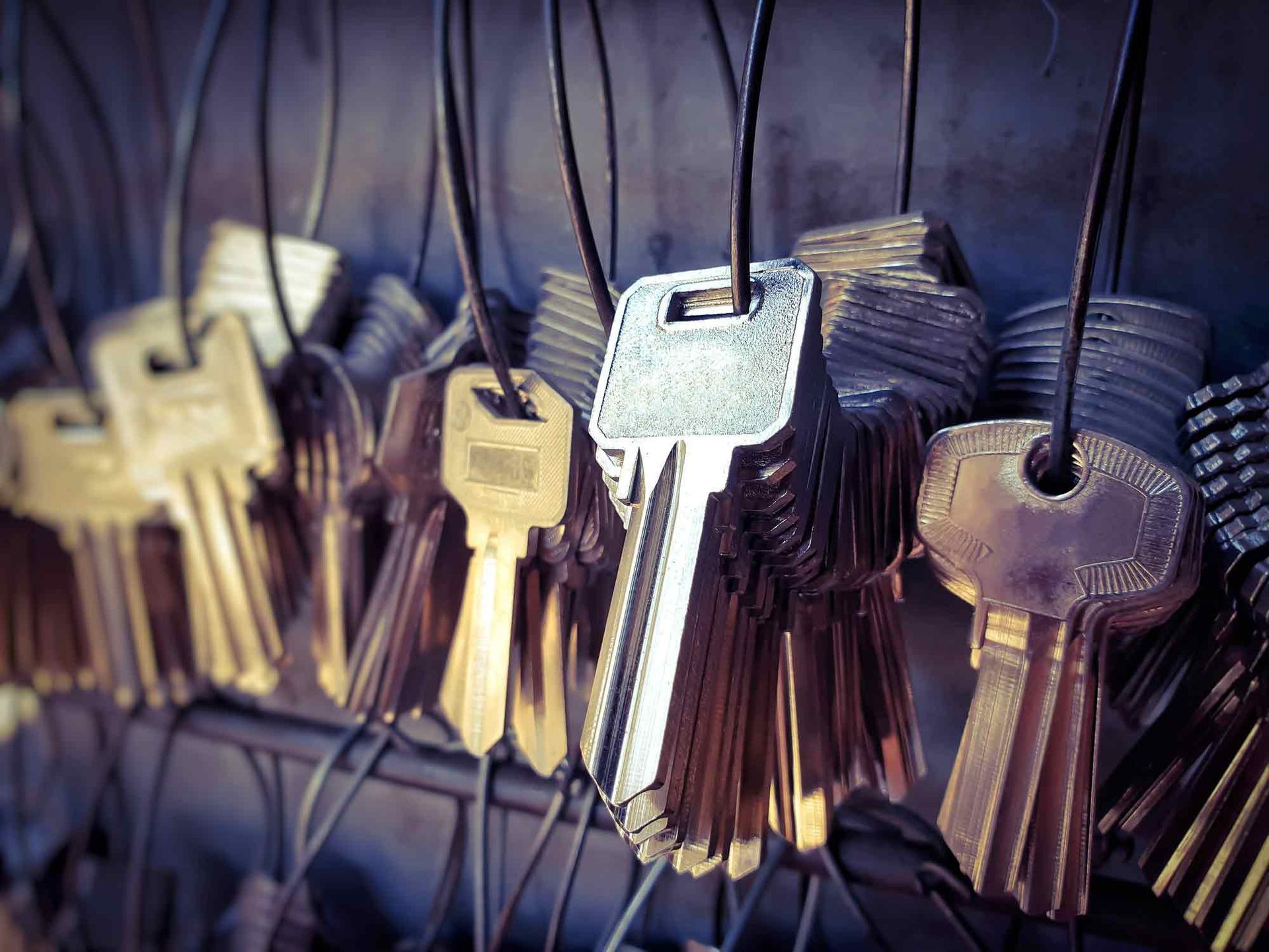 A bunch of keys are hanging on a wire.