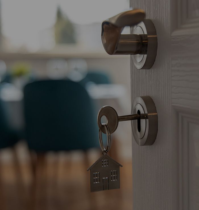 A door with a key and a house keychain in it.