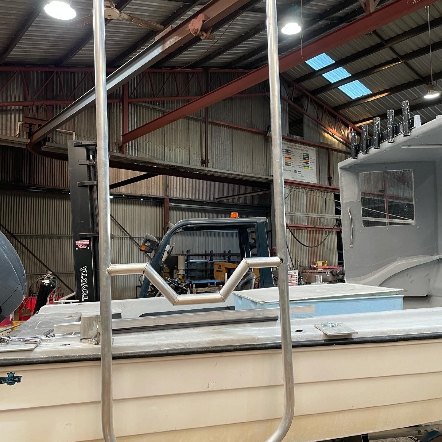 A boat is sitting in a warehouse with a ladder attached to it.