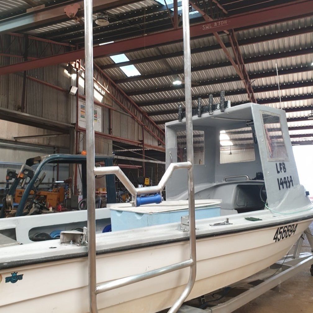 A boat with a ladder attached to it has the letters ua on the side