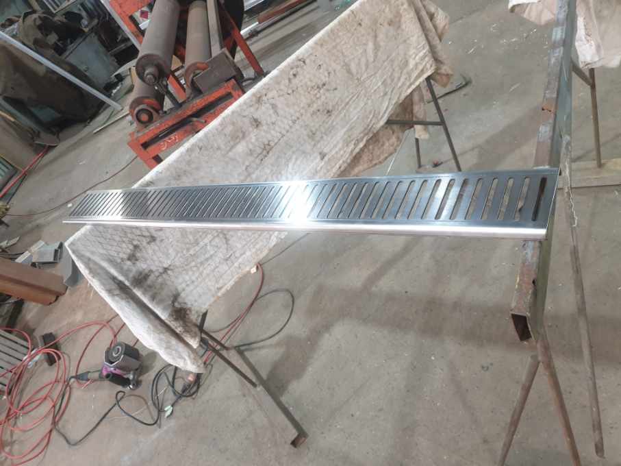 A piece of metal is sitting on top of a wooden table.