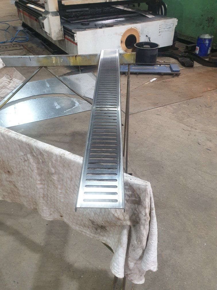 A stainless steel drain is sitting on top of a towel on a table.