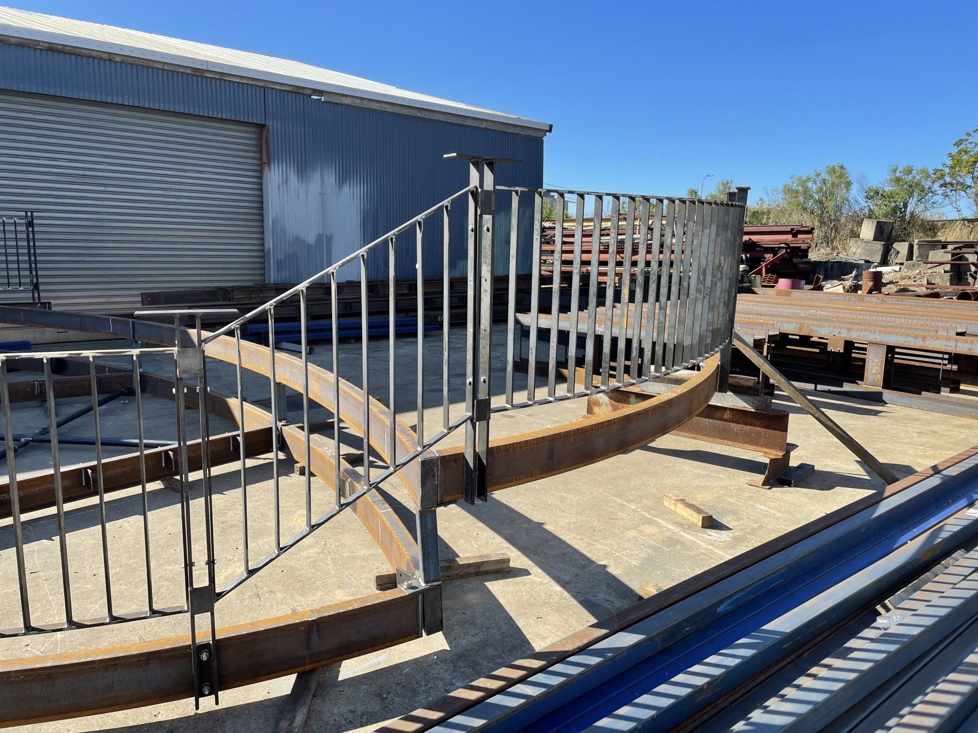 A staircase with a metal railing is sitting in front of a building.