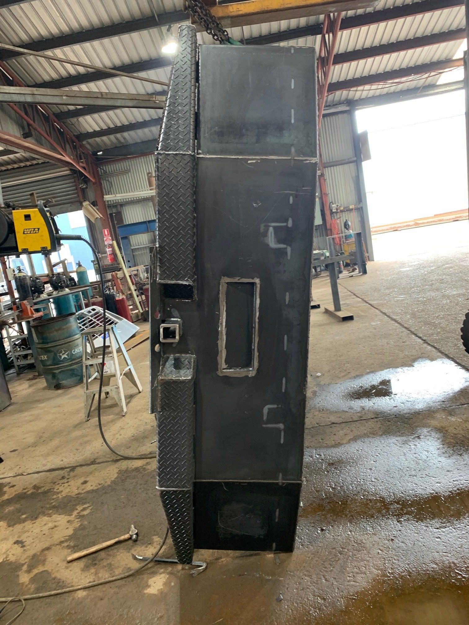 A large piece of metal is sitting in a garage.