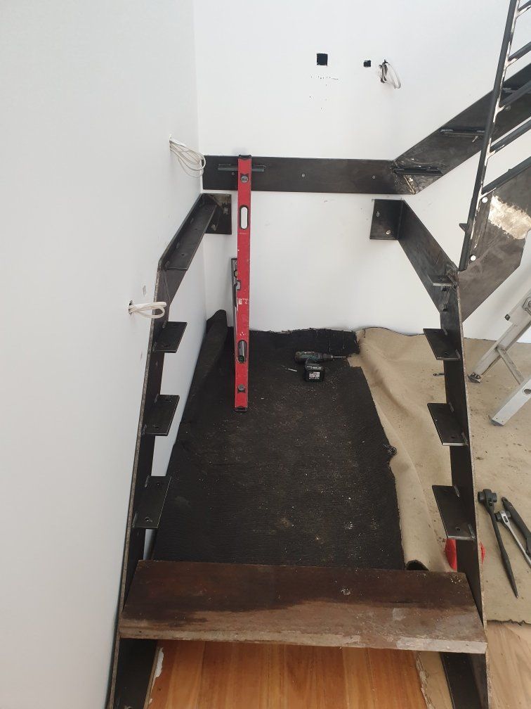 A staircase being built with a red level on the floor