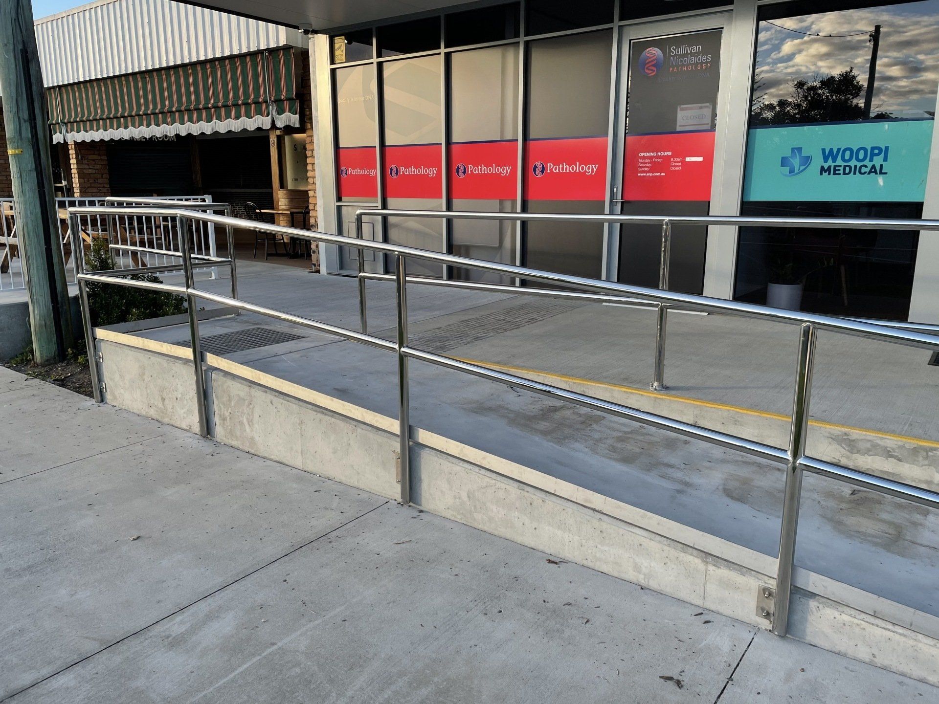 A ramp with a stainless steel railing in front of a building