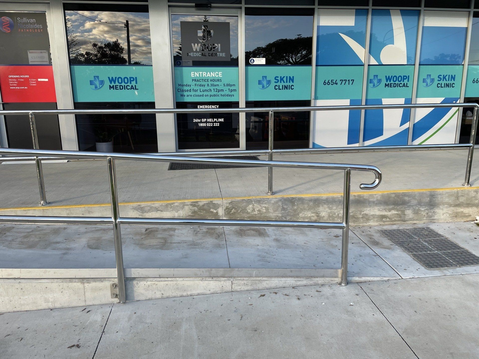 A stainless steel railing in front of a hospital