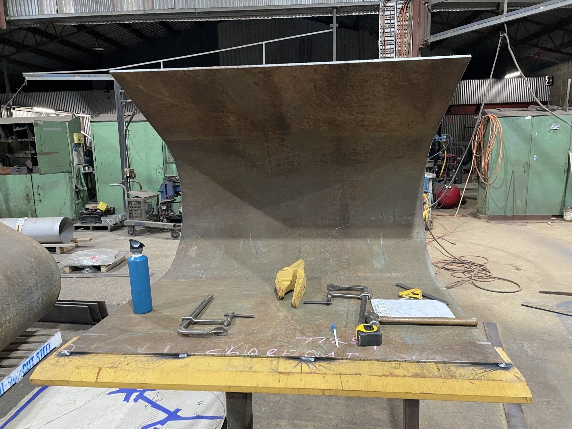 A large piece of metal is sitting on a table in a factory