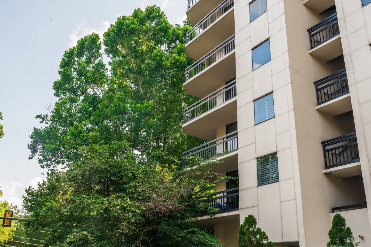 A residential area in Ansley Park, Georgia, with lush green trees nearby and blue skies