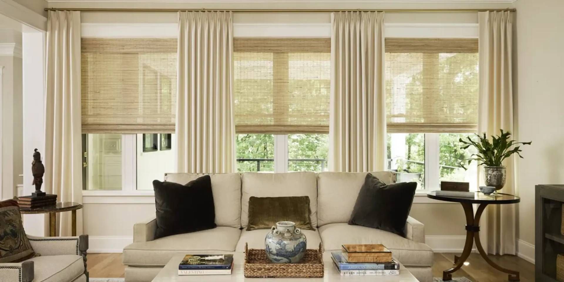 Chic living room with three windows, layered with woven shades and custom drapery near Atlanta, GA
