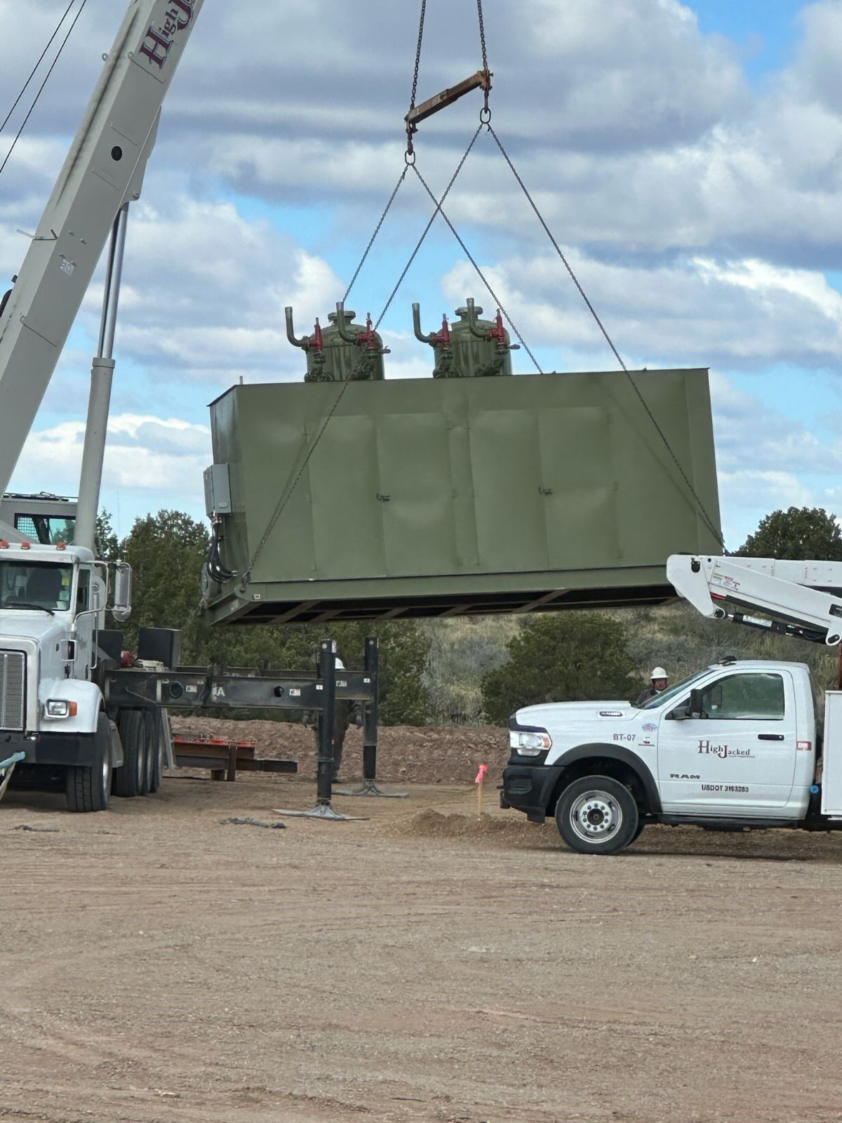 A truck is being lifted by a crane that has the word hydraulic on it