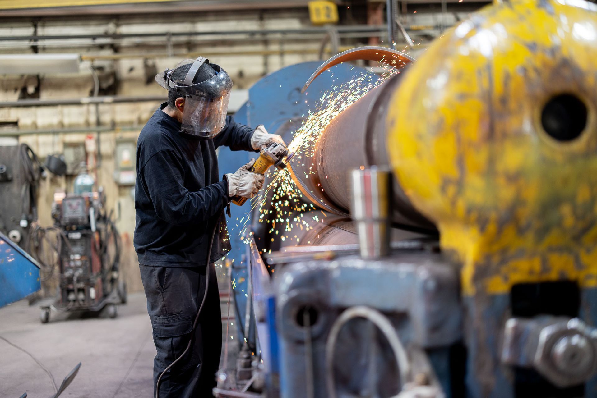 a Pesco employee wearing a welding mask is welding a pipe