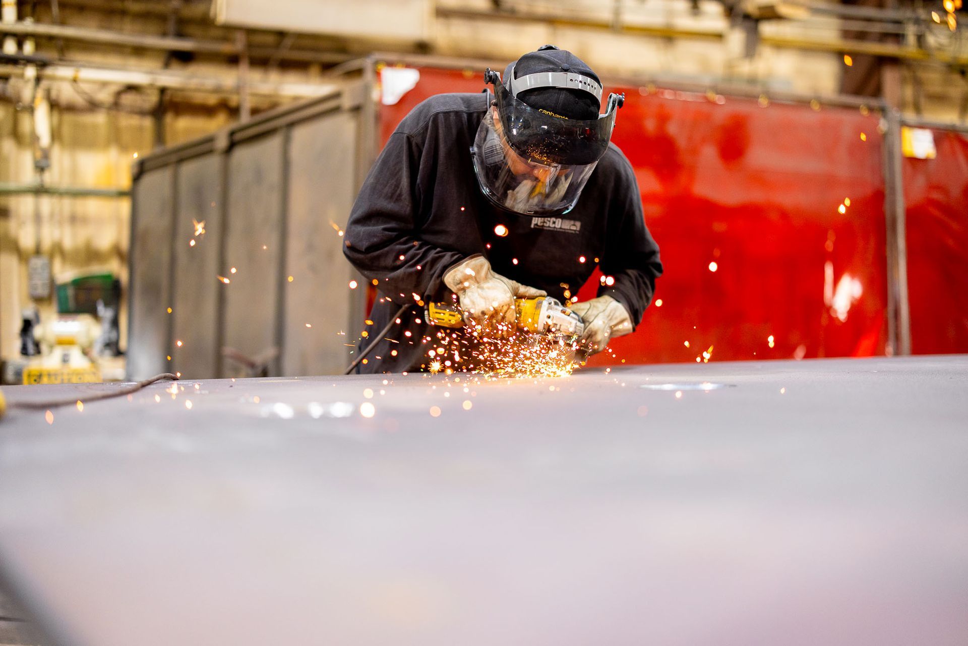 a Pesco employee wearing a welding mask is welding a pipe