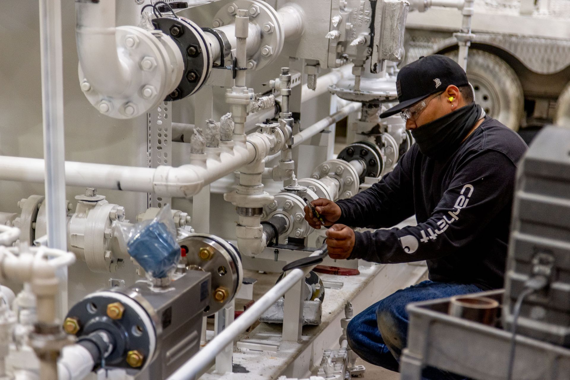 Pesco employee wearing a black carhartt shirt works on a machine