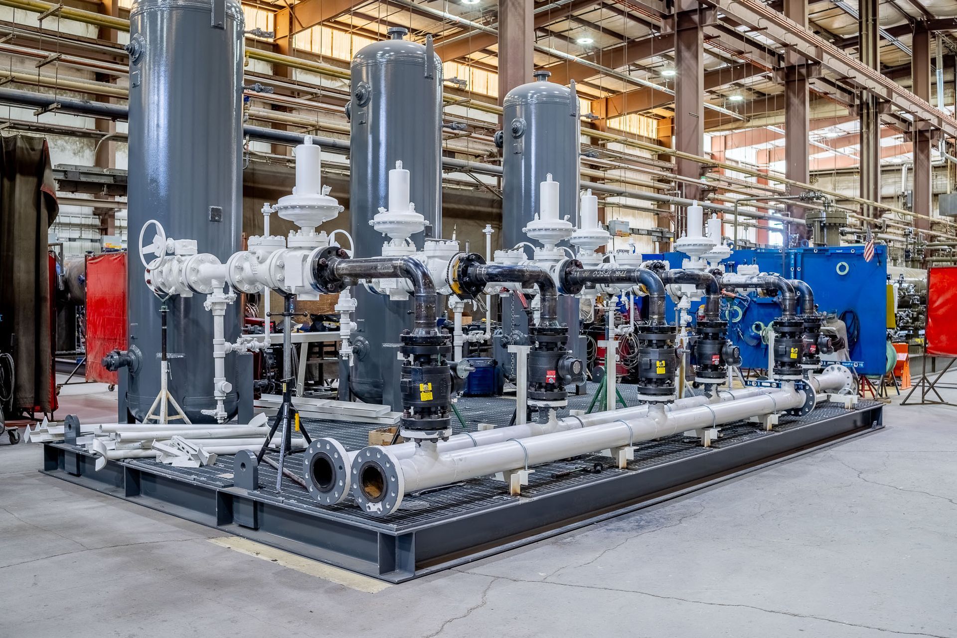 a bunch of pipes in a factory with one that says ' stainless steel ' on it