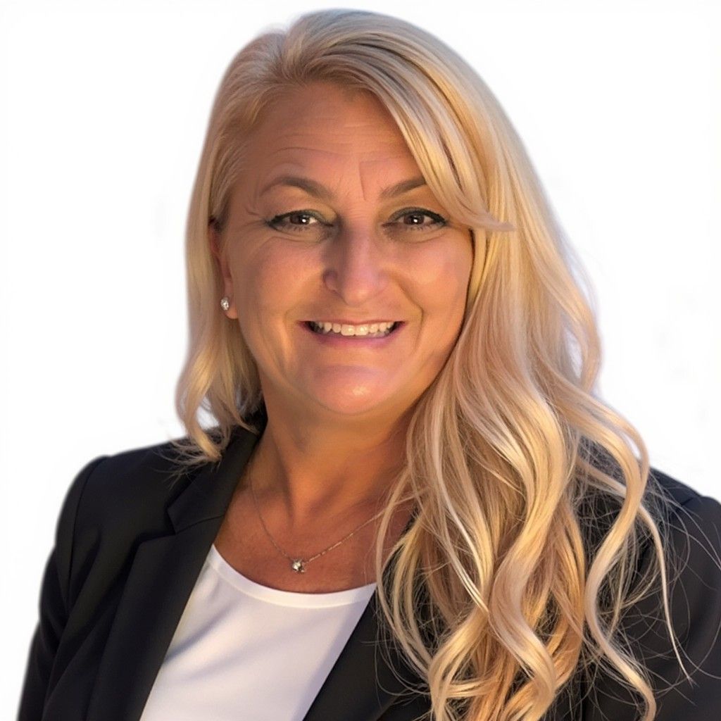 Smiling blonde woman in a black blazer and white top on a white background