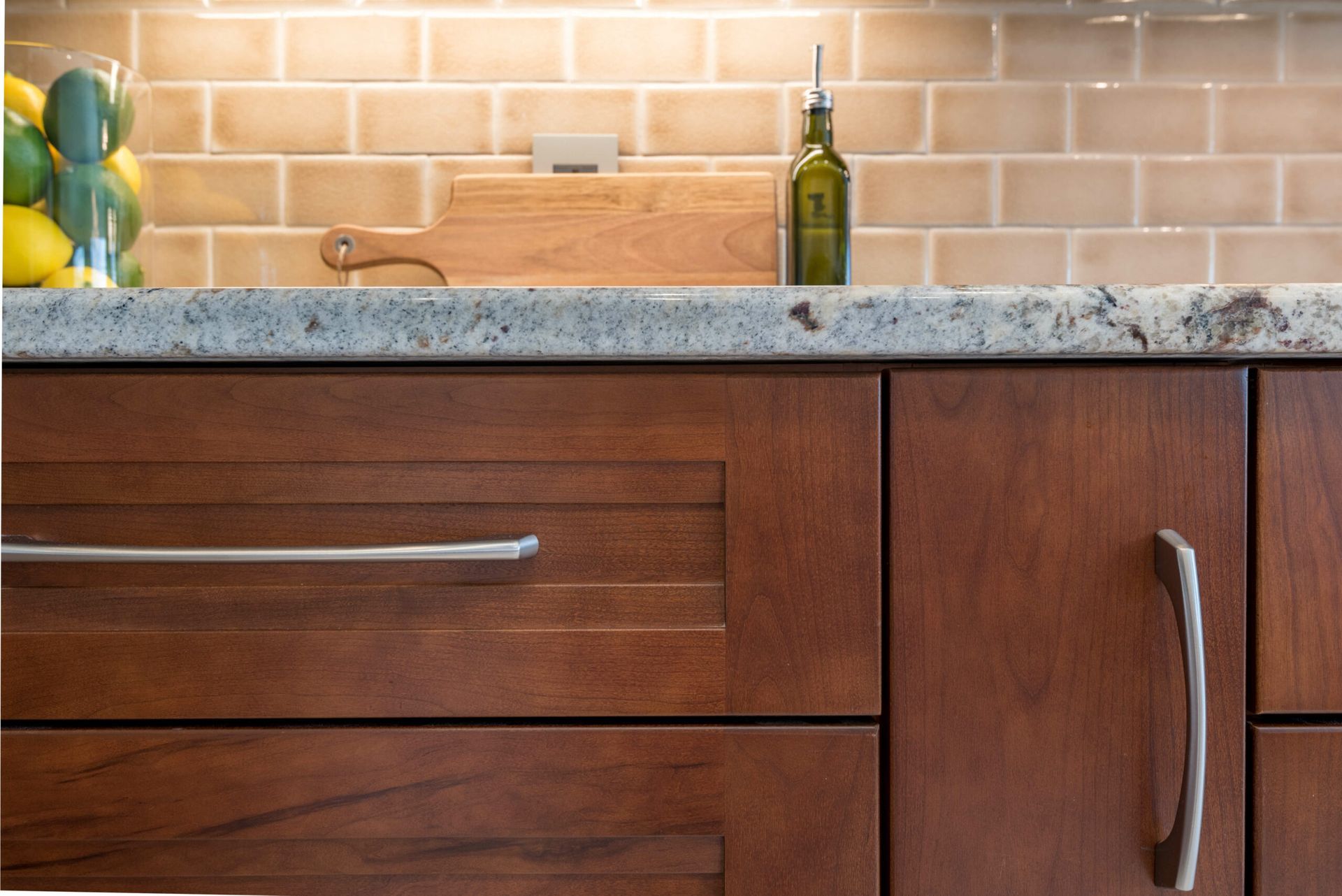 Kitchen countertop with granite surface, wooden cabinets, and a tiled backsplash