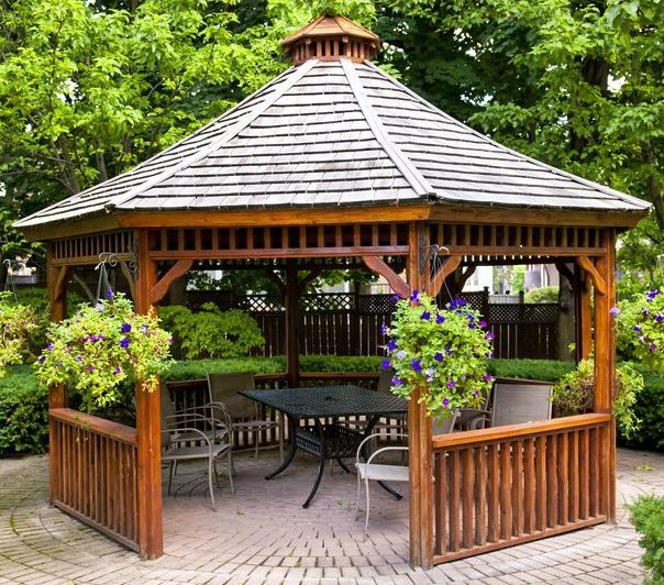 A Wooden Gazebo With a Table and Chairs in a Garden — TM Built Construction In Branxton, NSW