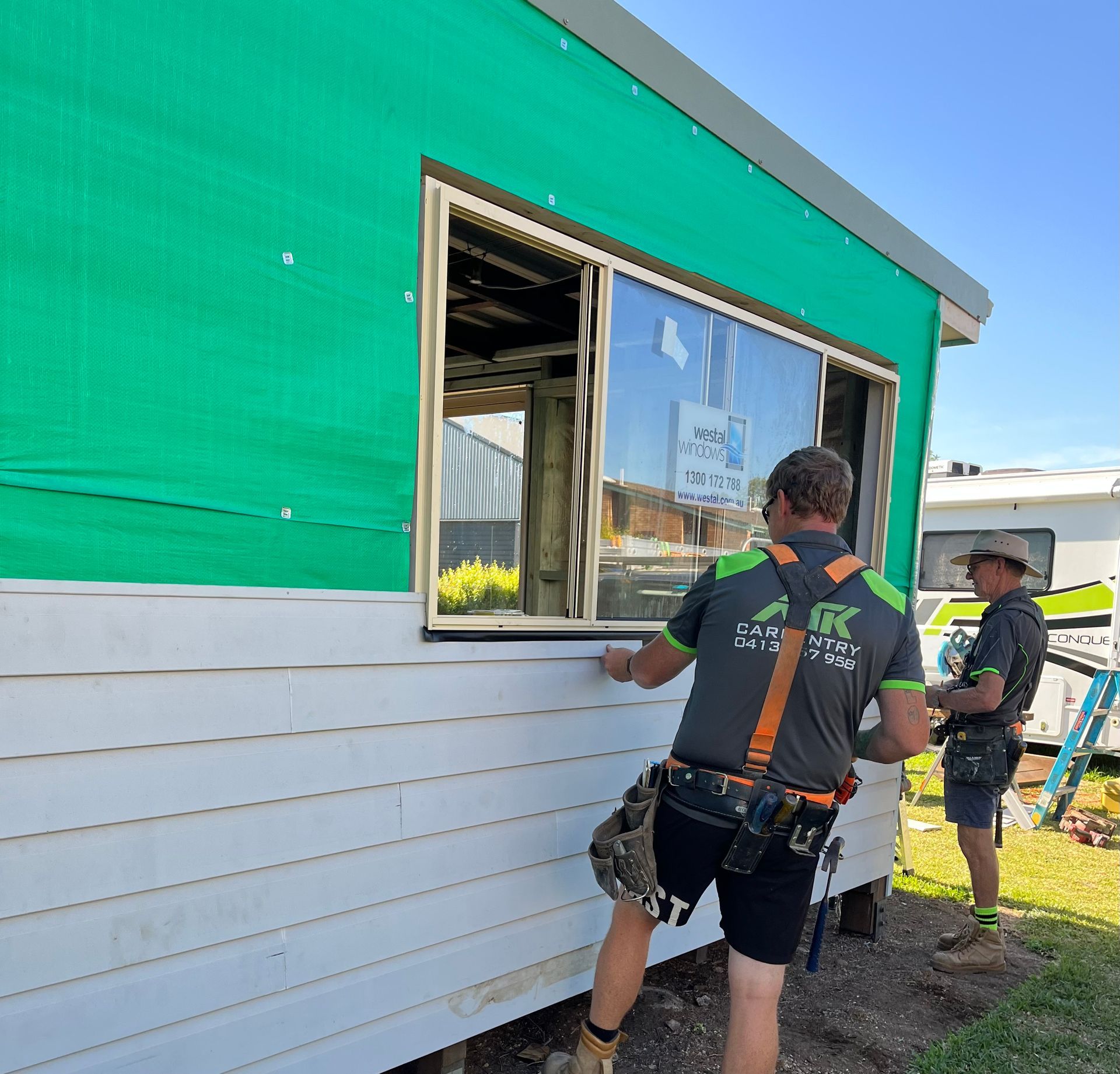 A Man is Measuring a Piece of Wood on a Table — TM Built Construction In Lochinvar, NSW