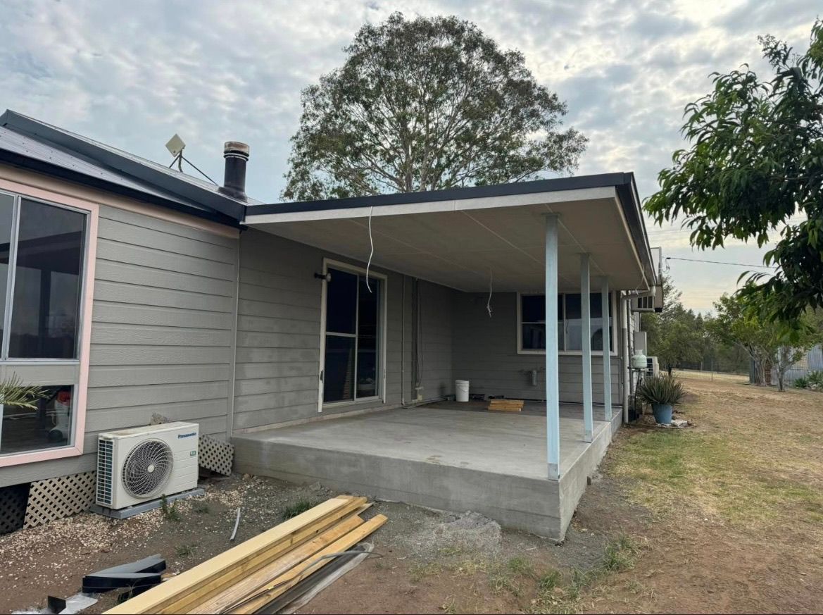 The back of a house with a porch and a lot of windows — TM Built Construction In Lochinvar, NSW