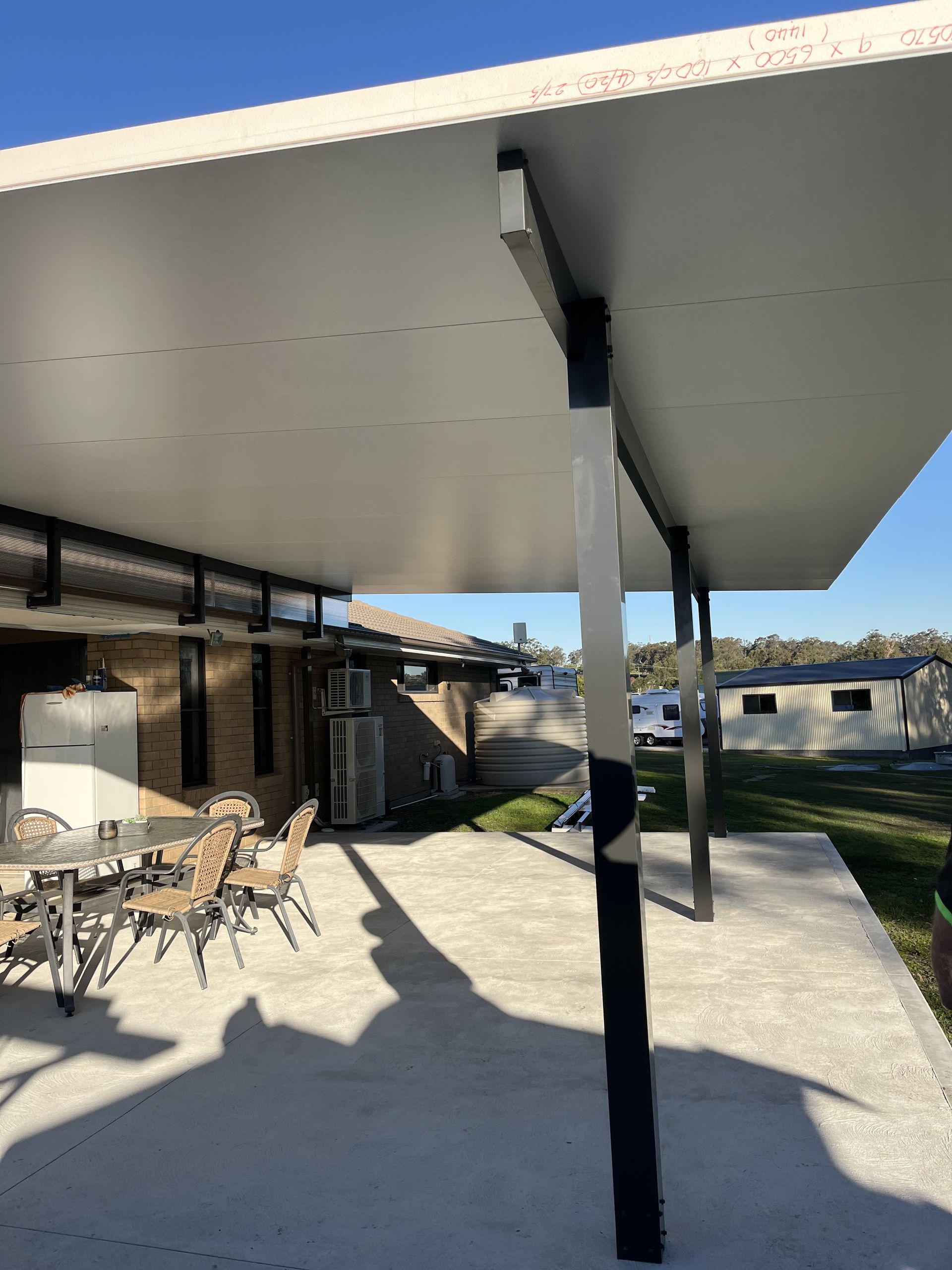 A Patio With a Pergola and a Fire Pit — TM Built Construction In Cessnock, NSW
