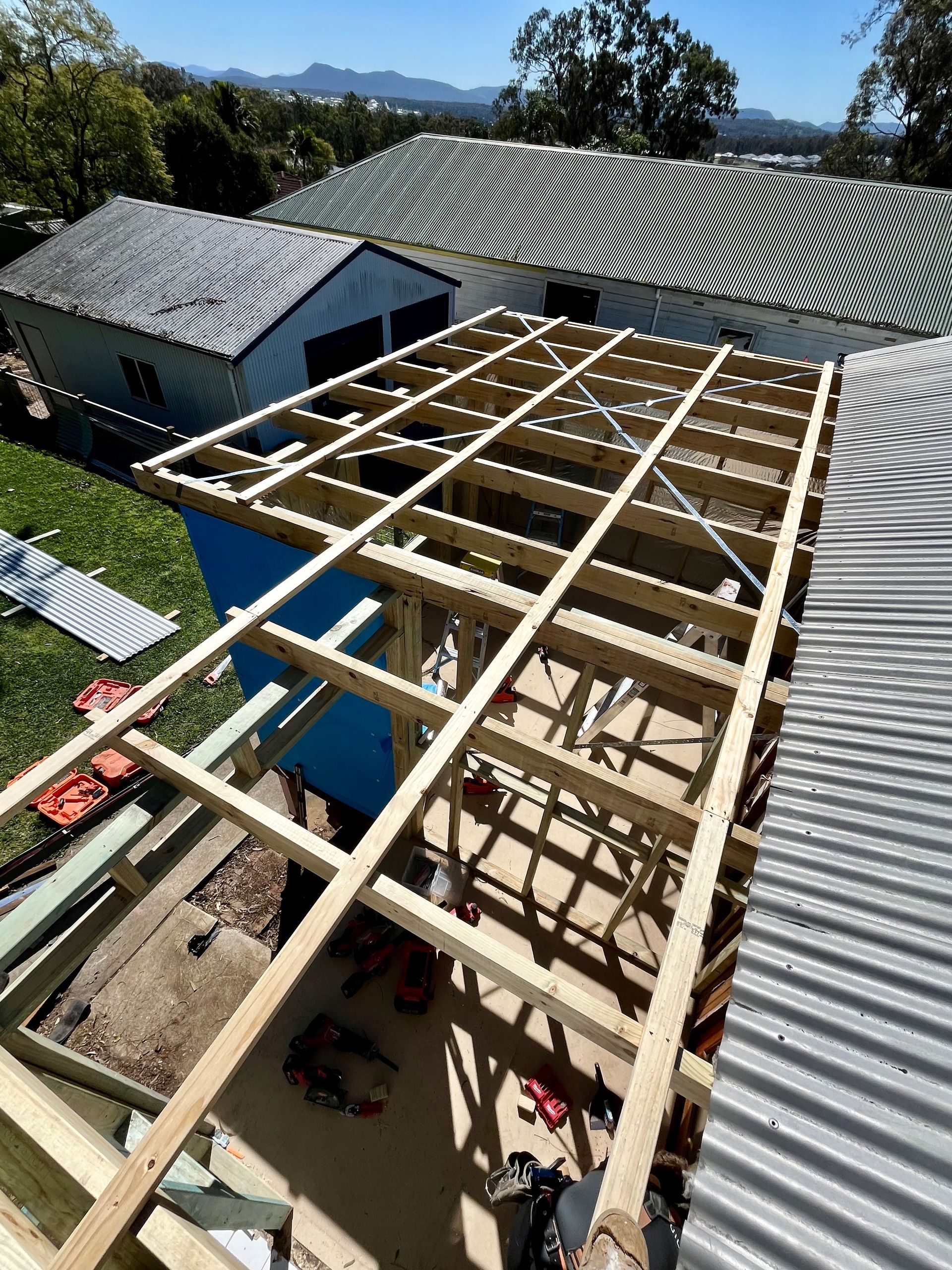 A wooden structure is being built on top of a house — TM Built Construction In Lochinvar, NSW