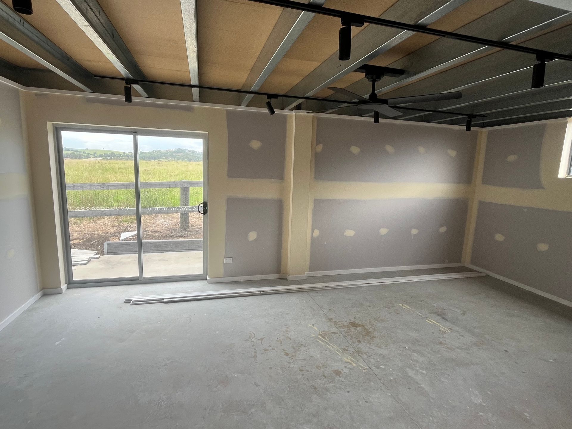 An empty room with a sliding glass door and a window — TM Built Construction In Lochinvar, NSW