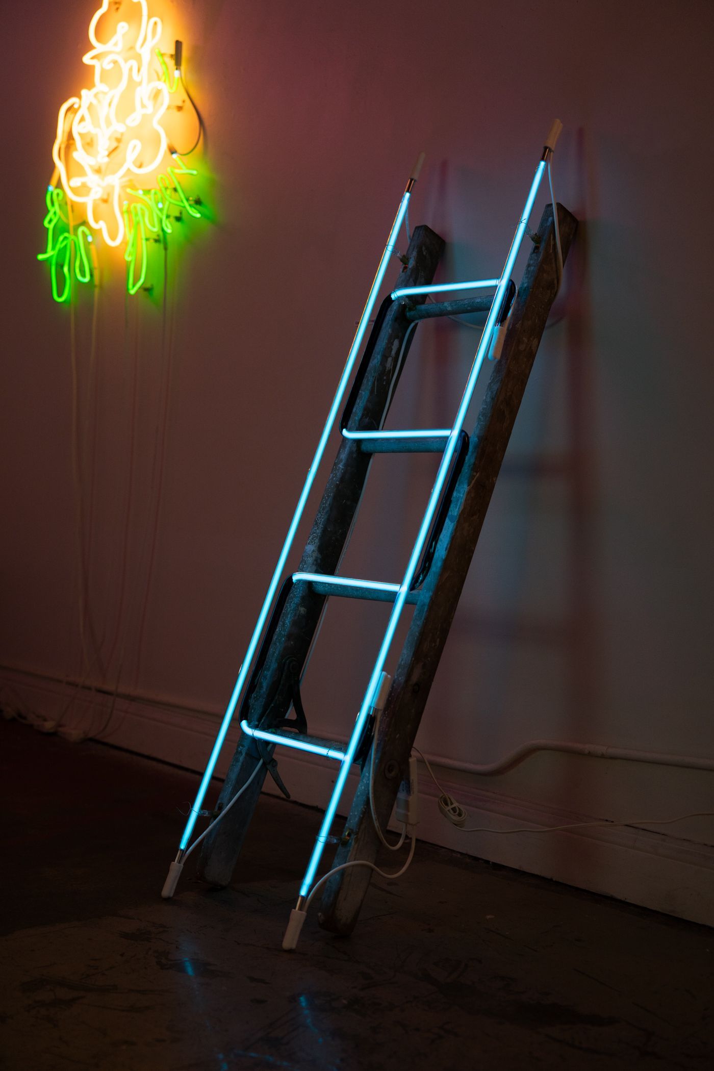 Blue neon outline of a ladder leaning against a wall in a dim room; art by Yale Wolf.