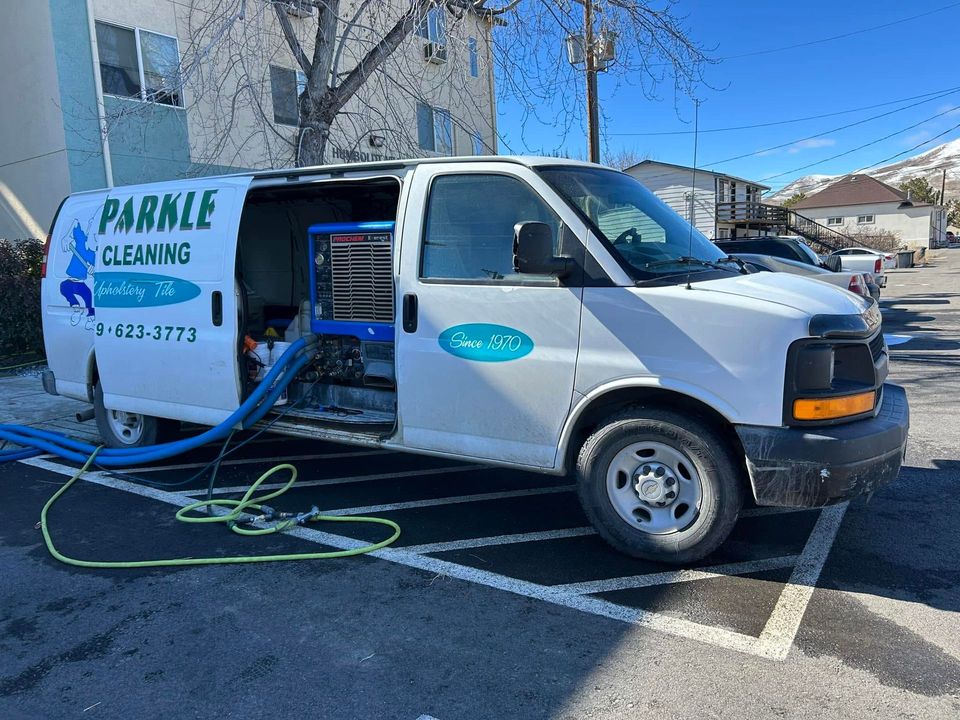 White Parable Cleaning van with open side door and hoses, parked in a lot under a clear sky