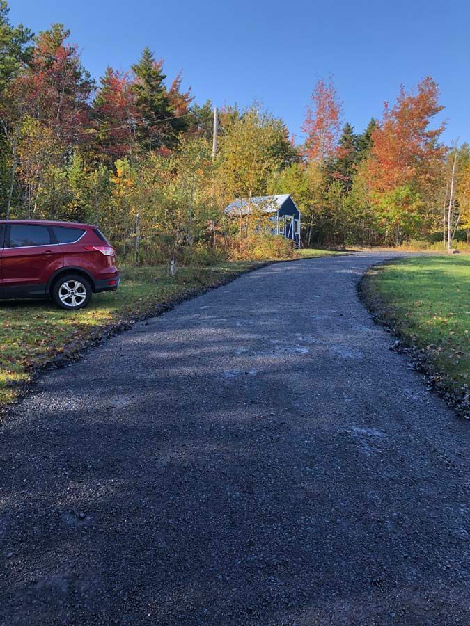 A red car is parked on the side of a road.